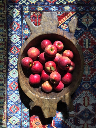 We have a lot of respect for each of the items you will find here. For example, the rug in this photo is a hand-crafted, fair trade piece of art for the floor and the unique wooden bowl was created by a Native American and holds a bountiful pile of local apples from one of our Amish neighbors.